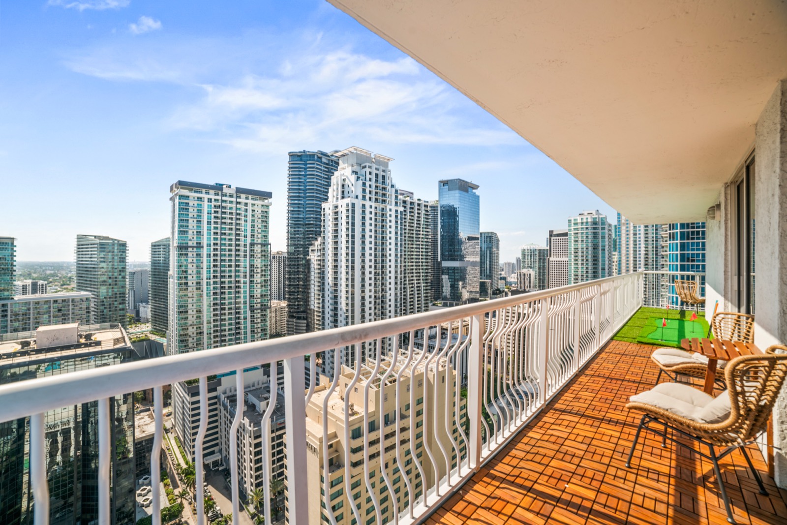 Wraparound balcony with Brickell skyline views, lounge seating and a mini putting green