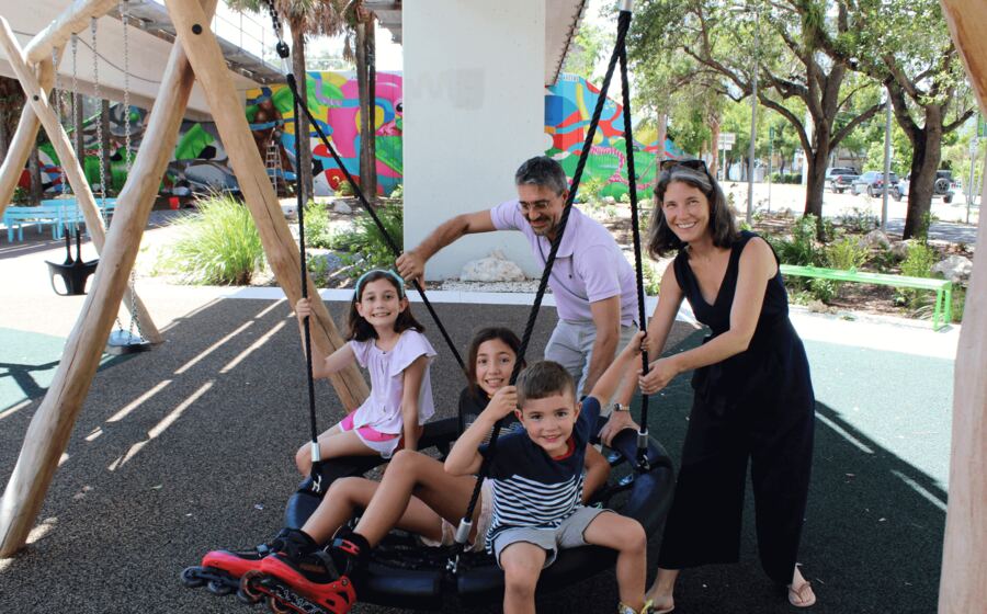 A family playing together on the large swing at The Underline's Hammock Playground